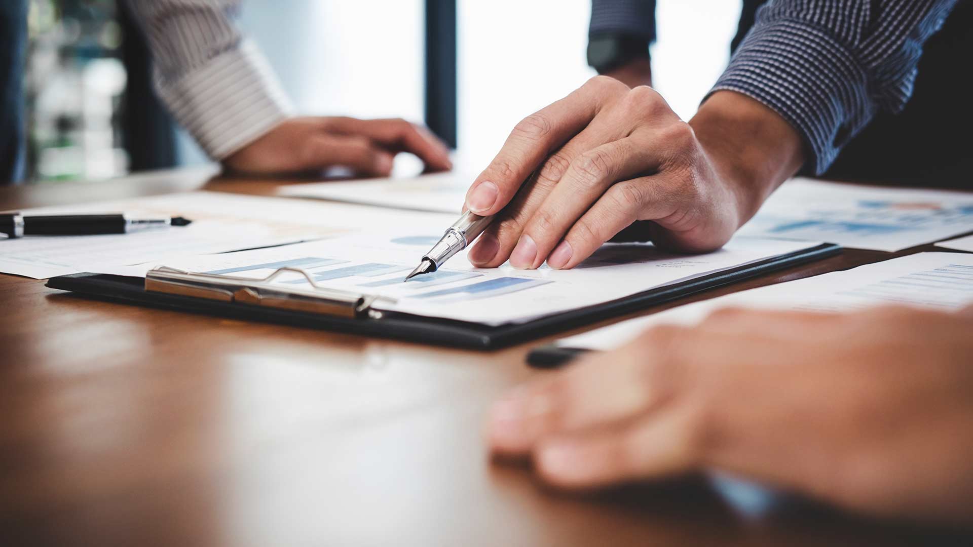 Geschäftsführer diskutieren und analysieren Diagramme und Tabellen zur Insolvenzanfechtung und Risikomanagement in einer Besprechung
